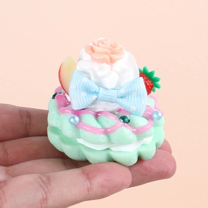 Faux cream doughnut keychain with pink strawberry and rose charms on a mint green base
