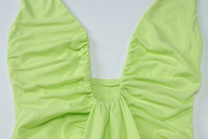 Vue détaillée du décolleté en U profond et du tissu plissé de la robe vert fluo