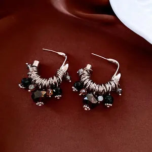 Vintage C-shaped silver drop earrings with dark glass tassels on brown silk backdrop