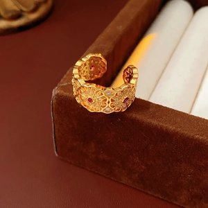 Dettaglio dell'anello a fiori placcato oro 18k con pietra rosso rubino e pizzo