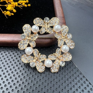 Detail of a vintage golden butterfly brooch with sparkling crystals and white pearls