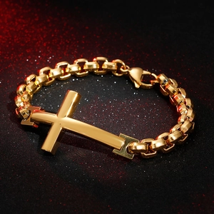 Detailed view of polished gold cross pendant on a thick round link chain bracelet