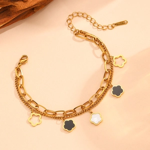 Dettaglio del bracciale a doppio strato in acciaio dorato con ciondoli a fiori bicolore
