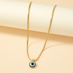 Golden snake chain necklace with Turkish blue evil eye pendant on minimalist pedestal