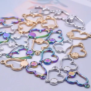Macro shot of heart-shaped hollow metal pendants in gold, silver and rainbow finish