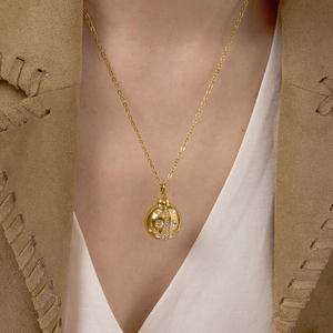 Collier coccinelle doré élégant avec cristaux brillants sur une fine chaîne en titane