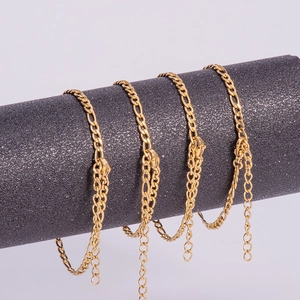 Detail of 18K gold plated Figaro chains with lobster clasp on a cylindrical display stand