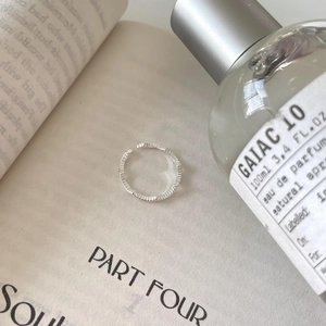 Chic 925 sterling silver wavy open ring with fine vertical texture on book background