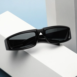 Y2K punk style black wrap-around sunglasses displayed on geometric architectural blocks