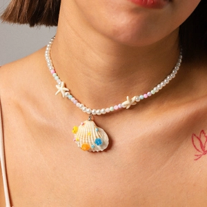 Close-up of ocean-style necklace with starfish, natural shell pendant and colorful beads