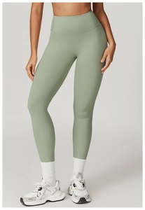 Detail of high-waisted sage green yoga leggings with supportive wide waistband