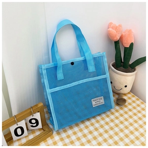 Detail of blue mesh travel tote bag with metal snap button and Fashion Bag label