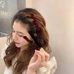 Detail showing three flocked rose-shaped hair clips in wine red, black, and brown colors