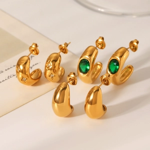 Detailed view of 18K gold C-shape stainless steel earrings with zircon and green gemstones
