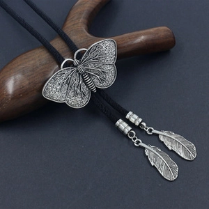 Detailed macro view of retro butterfly bolo tie with vintage silver wing sliders