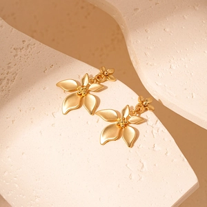 Detailed macro view of golden flower earrings with intricate textured petals and core