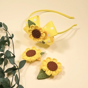 Detail of yellow sunflower headband and matching clips with polka dot ribbon for girls
