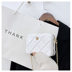 Detail of white PVC jelly bag featuring diamond lattice pattern and gold rose ornament