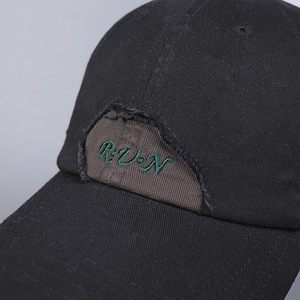 Black cotton baseball cap with distressed brown patch and green RUN embroidery detail