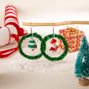 Detailed view of Christmas earrings with Santa and tree charms in green festive wreaths