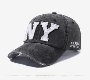 Detail of NY embroidery and distressed brim on washed denim baseball cap