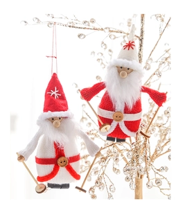 Gros plan de deux lutins de Noël tricotés avec skis en bois et bonnets rouges