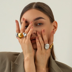 Exaggerated 18K gold and silver chunky spherical rings worn by a model in a modern style
