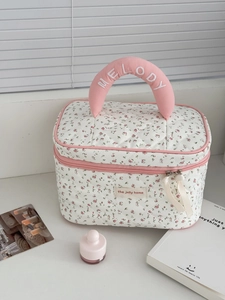 Détail d'une trousse à maquillage fleurie matelassée avec poignée brodée MELODY et doubles rubans