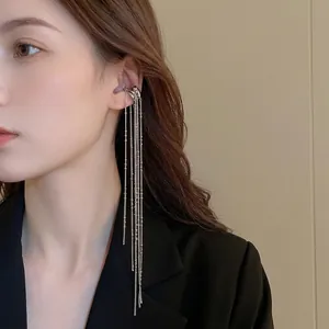 Minimalist silver irregular C-shape chain tassel ear bone clip worn with a black blazer