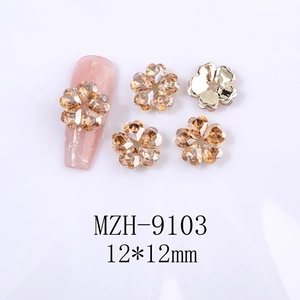 Detail of 12x12mm hollow five-petal flower nail charms with rhinestones on a pink nail