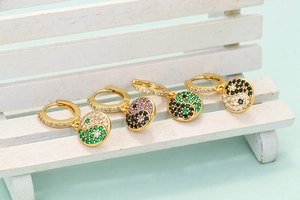 Detail of colorful Tai Chi Yin Yang hoop earrings with cubic zirconia on a white prop
