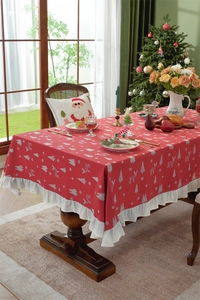 Detail view of red Christmas cotton tablecloth with white reindeer patterns and ruffled edges
