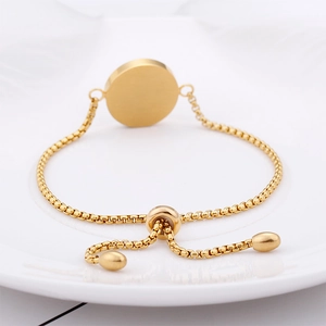 Detail of a gold-plated stainless steel box chain bracelet with an adjustable sliding clasp