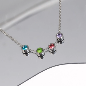 Détail d'un collier argenté avec quatre pierres de zircon colorées de 5 mm de diamètre