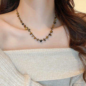 Détail du collier en pierre œil de tigre irrégulière avec texture perlée bohème