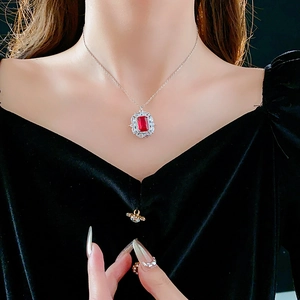 Vue macro d'un collier argenté avec pendentif en zircon rectangle rouge sur un mannequin