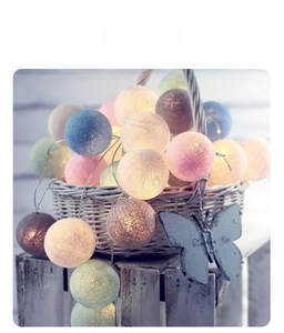 Colorful LED cotton ball string lights in a rustic basket for cozy room decoration