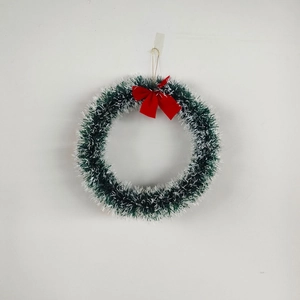 Detailed view of green and white Christmas wreath with a large red velvet bow on top