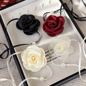 Detail of elegant rose fabric chokers in multiple colors with pearl accents