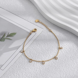 Minimalist gold stainless steel bracelet with five round cubic zirconia bezel set stones