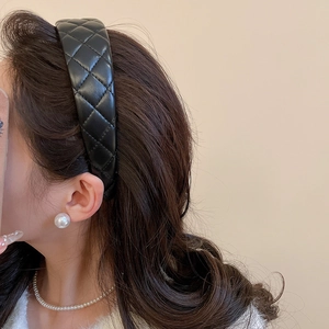 Detail of black quilted leather headband with elegant texture and padded design