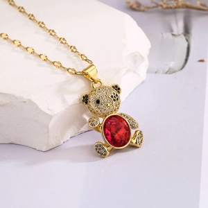 Close-up of gold bear pendant with red oval crystal and sparkling cubic zirconia stones