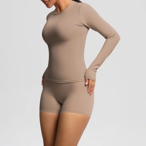 Detail view of mocha brown long-sleeve yoga top and matching shorts from side-back angle