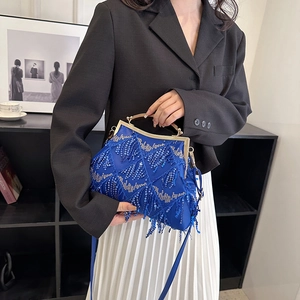 Detail of royal blue sequined tassel evening bag with gold metal handle and frame