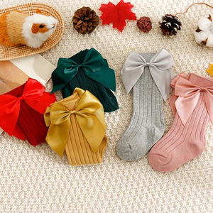 Chaussettes hautes en tricot pour bébé avec grands nœuds en satin et textures de fête