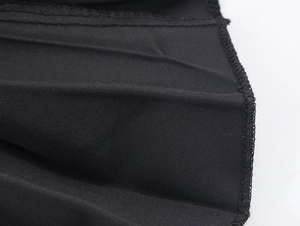 Close-up of black mesh fabric texture with precise stitching and pleated detail