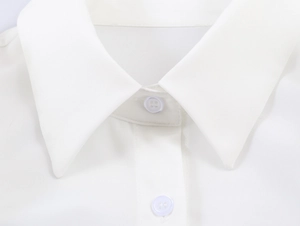 Detail shot of white sleeveless shirt featuring ruffle collar and neat button placket