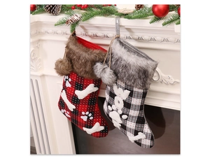 Detail view of plaid Christmas stockings with faux fur trim hanging on a festive fireplace