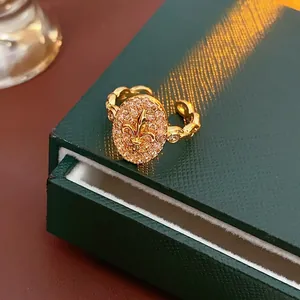 Bague fleur de lys dorée vintage avec cristaux pavés sur un anneau en maille tressée