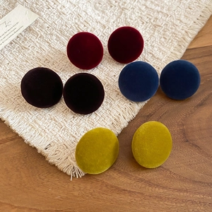 Close-up of four pairs of velvet button earrings in burgundy, brown, blue, and yellow colors
